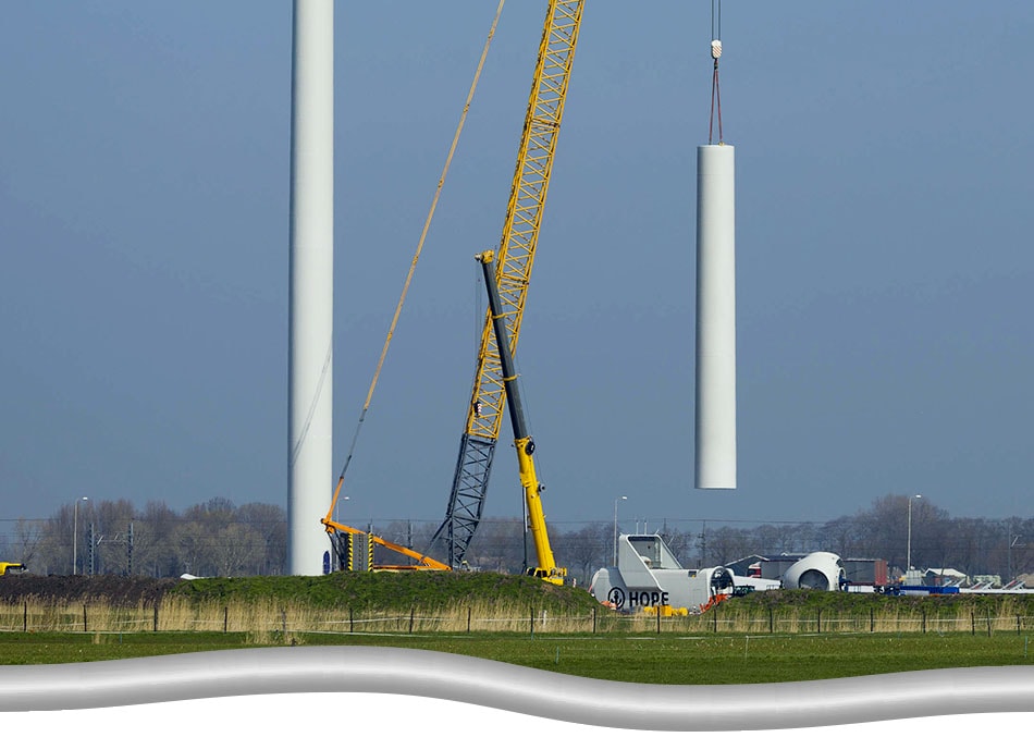 Auxiliary Crane Procurement and Operation. Yellow and black auxiliary crane working next to the main crane for the construction of a wind turbine.