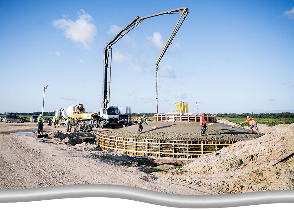 Pre-construction of onshore wind energy project. Workers building the base of a wind turbine.