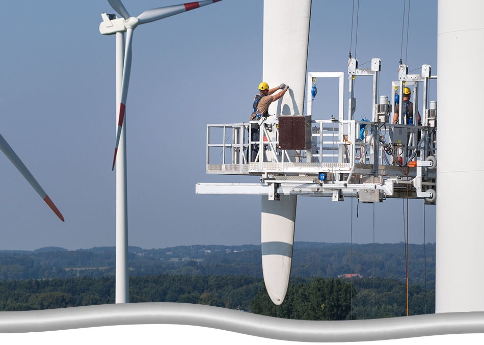 Two workers up on large man basket/ platform, doing maintenance on a wind turbine blade