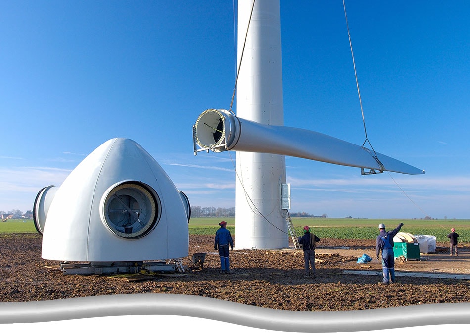 Project managers overseeing and guiding the construction of a wind turbine. Turbine blade being lifted.